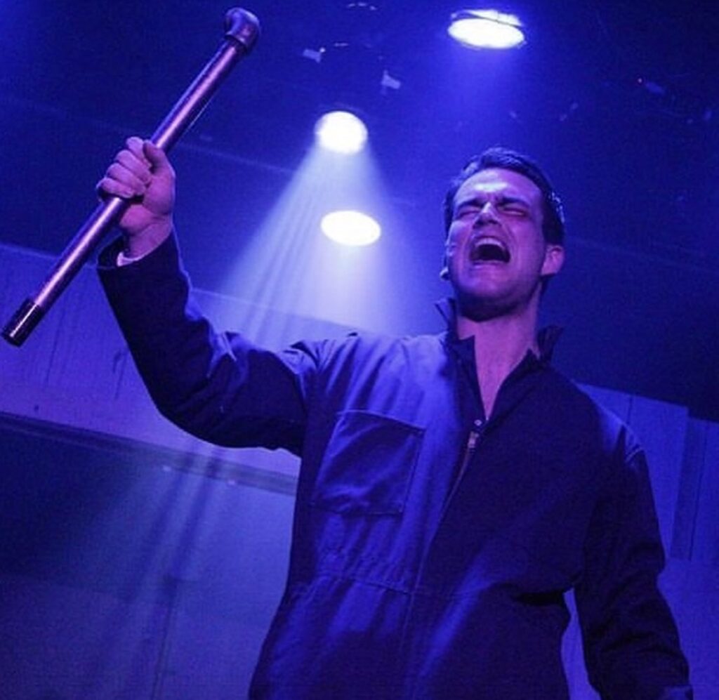 Actor Ryan Griffin Singing passionately with hand raised in sky